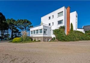 a large white house on the side of a road at Résidence route de la corniche vue mer in Plestin-les-Grèves