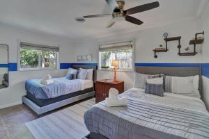 a bedroom with two beds and a ceiling fan at The Dreamcatcher - 4 Bed, 2 Bath, Private Heated Pool, BBQ, Game Room, Park in Fort Lauderdale
