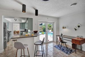 a kitchen with a counter and stools in a room at The Dreamcatcher - 4 Bed, 2 Bath, Private Heated Pool, BBQ, Game Room, Park in Fort Lauderdale