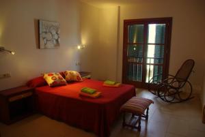 a bedroom with a red bed and a window at Na Margarida in S'Illot