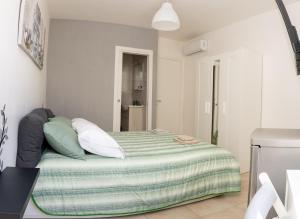 um quarto com uma cama com um cobertor verde em La Julienne Green em Nápoles