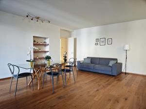ein Wohnzimmer mit einem Tisch, Stühlen und einem Sofa in der Unterkunft Hostdomus - Lagrange Luxury Apartments in Turin
