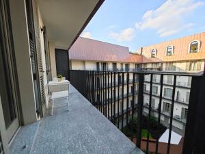 einen Balkon mit einem Stuhl und Blick auf ein Gebäude in der Unterkunft Hostdomus - Lagrange Luxury Apartments in Turin