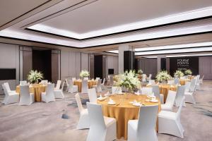 una sala da ballo con tavoli e sedie bianche e una stanza piena di tavoli e di bianco di Four Points by Sheraton Shanghai Jiading a Shanghai