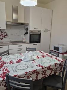 una cucina con tavolo e tovaglia rossa e bianca di Appartamento centralissimo,a 20 mt dal mare a Varazze