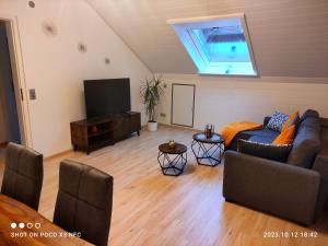 ein Wohnzimmer mit einem Sofa und einem TV in der Unterkunft Lieblingsort in Freudenstadt