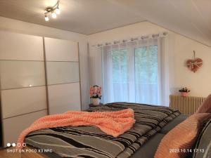 ein Schlafzimmer mit einem Bett mit einer orangefarbenen Decke in der Unterkunft Lieblingsort in Freudenstadt