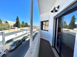 a building with a balcony with cars on the street at Campus 121 in Faro