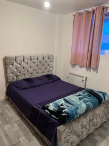 a bedroom with a bed with purple sheets and a window at Room in the centre of Portsmouth in Portsmouth