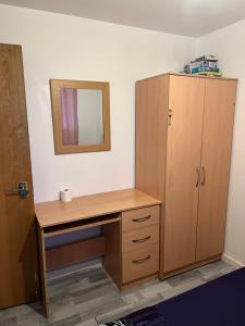 a bathroom with a wooden desk and a mirror at Room in the centre of Portsmouth in Portsmouth