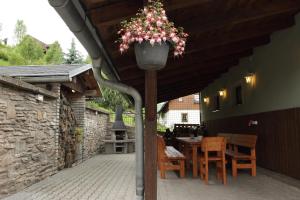 a patio with a table and a planter with flowers at Chalupa Maršovka in Horní Maršov