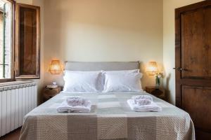 a bedroom with a bed with two towels on it at Il Borghetto - La Ghibellina Townhouse in Castelnuovo dellʼAbate