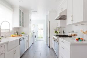 una cocina blanca con armarios blancos y electrodomésticos blancos en Countryside Farm Estate - Bnb en Orillia
