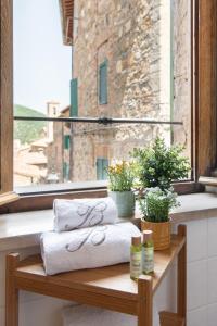 a couple of towels sitting on a table in front of a window at Il Borghetto - La Ghibellina Townhouse in Castelnuovo dellʼAbate