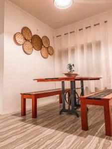 una mesa y bancos en una habitación con platos en la pared en Simple, bohemian style 1-bedroom bungalow +parking, en San Juan