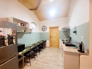 a kitchen with a row of counters and chairs at Apartamenty i pokoje gościnne pod lasem in Nadarzyn