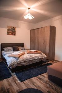 1 dormitorio con 1 cama con pared de madera en Prenoćište Lelić en Valjevo