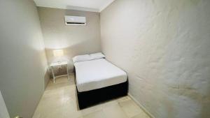a small room with a small bed and a nightstand at Capitel Hostel in Cartagena de Indias