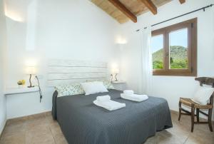 1 dormitorio con 1 cama con 2 toallas en Owl Booking Villa Margarita - 15 Min Walk to the Beach, en Puerto Pollensa