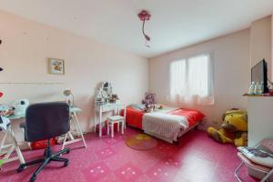 1 dormitorio con cama, mesa y escritorio en Maison quartier résidentiel, en Saint-Priest