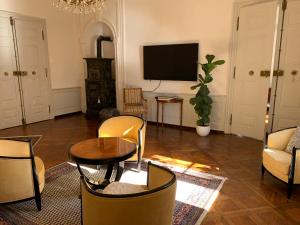 a living room with a tv and a table and chairs at Napoleonsuite auf Schloß Hürbel in Gutenzell-Hürbel