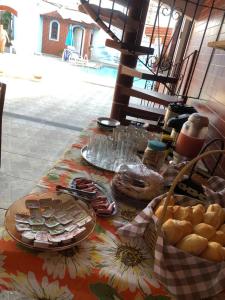 a table with plates of food on top of a table at Hostel&Pousada Equilíbrio in Praia Grande