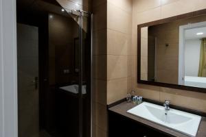 bagno con lavandino e specchio di CASA CON PATIO a Pozoblanco