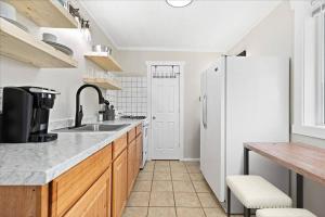 a kitchen with a sink and a white refrigerator at Unit 5: Sun drenched studio with tranquil vibes in Billings