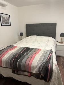 Un dormitorio con una cama con una manta a rayas. en B & E Apartment, en Huddinge