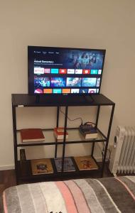 a tv on top of a shelf with a television on it at B & E Apartment in Huddinge