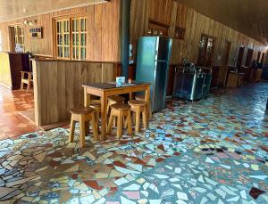 une cuisine avec une table et des tabourets sur un sol en mosaïque dans l'établissement Residencial Coya, à David