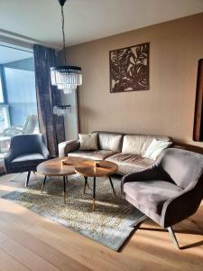 un soggiorno con divano e 2 tavoli di Majestic Golden View a Bratislava