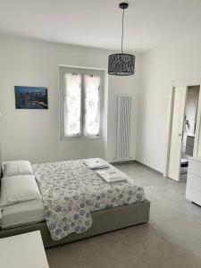 a white bedroom with a bed and a window at Deluxe Apartment Self Check in Parking in Genova