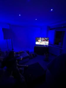 a person laying on a couch in a blue room with a television at FLY5 Gaming Spot in Náchod