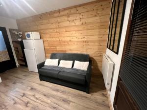 ein Wohnzimmer mit einem Sofa und einem Kühlschrank in der Unterkunft Orrianes'home in Les Orres