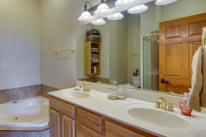 La salle de bains est pourvue de 2 lavabos, d'une baignoire et d'un miroir. dans l'établissement Burnsville Condo Screened Porch and Mountain Views!, à Burnsville