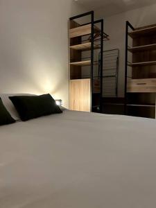 een wit bed met zwarte kussens in een slaapkamer bij Appartement 42 in Fort-de-France