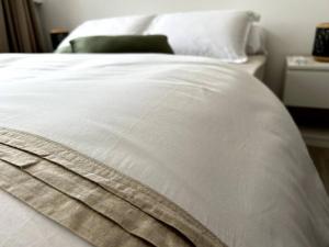 een close-up van een bed met witte lakens bij Appartement 42 in Fort-de-France
