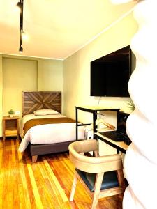 1 dormitorio con 1 cama y escritorio con ordenador en Apartamentos Montes en Cusco
