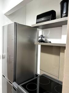 een keuken met een roestvrijstalen koelkast en een plank bij Appartement 42 in Fort-de-France