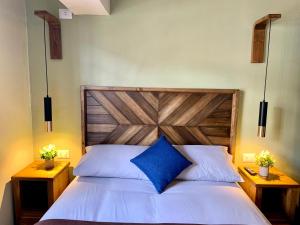 1 dormitorio con 1 cama grande y cabecero de madera en Apartamentos Montes en Cusco