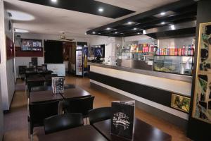 a restaurant with tables and chairs and a counter at Hôtel restaurant Le Parisien in Lourdes