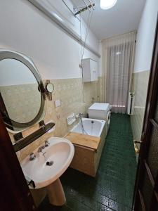 bagno con lavandino, vasca e specchio di Ama's house a Piacenza