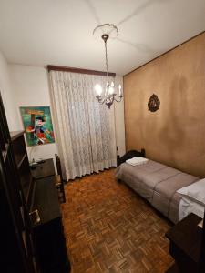 a bedroom with a bed and a chandelier at Ama's house in Piacenza