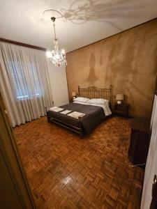 una camera con un grande letto e un lampadario a braccio di Ama's house a Piacenza