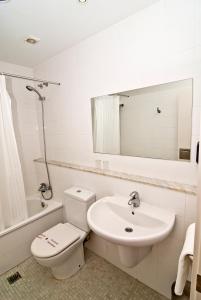 y baño con aseo, lavabo y espejo. en Hotel Puerta de la Serrania en Lliria