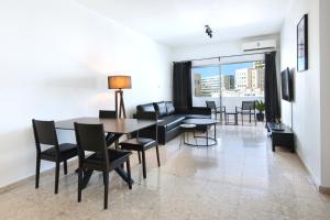 a living room with a table and chairs and a couch at Urban Condo 10 - 2 Bdr in Nicosia