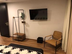 sala de estar con TV y silla en Casa Tlaxcalli by Beddo Hoteles en Tlaxcala de Xicohténcatl