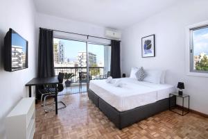 um quarto com uma cama, uma secretária e janelas em Urban Condo 10 - 2 Bdr em Nicósia