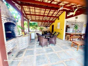 un patio con mesa, sillas y chimenea en Branca Tropical Brasil Residencial- Taperapuan, en Porto Seguro